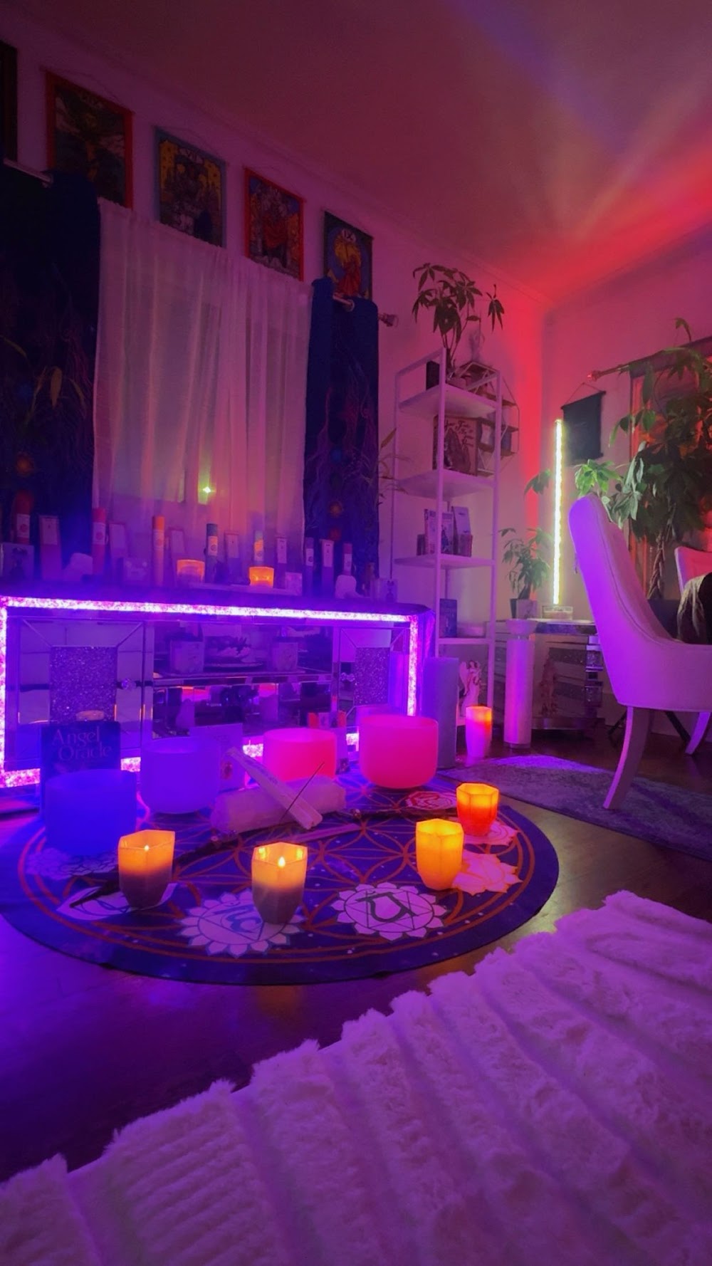 Inside The Psychic Studio — neon-lit reading room with singing bowls, candles and chakra rug